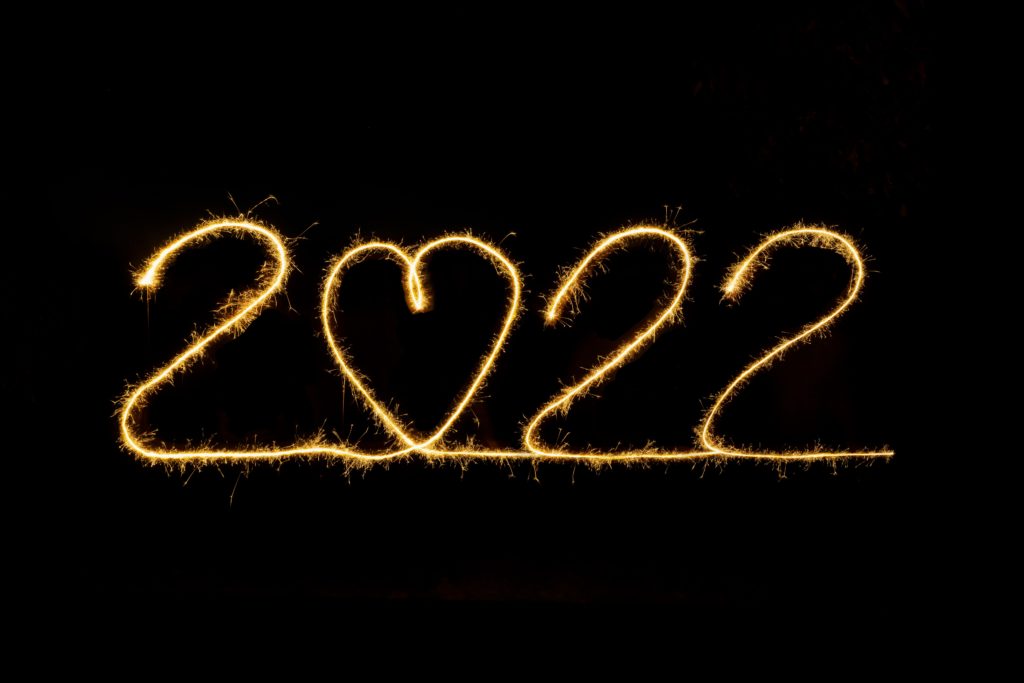 2022 written with sparklers on black background, heart instead of a zero