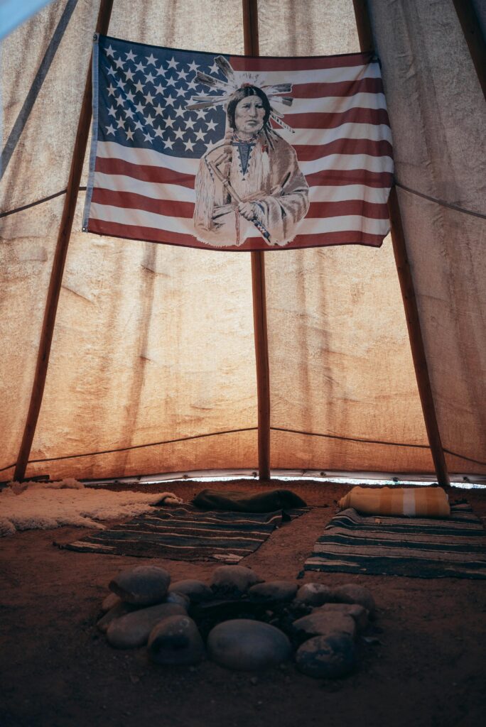 Authentic Native American teepee with historical decor and symbolic flag.