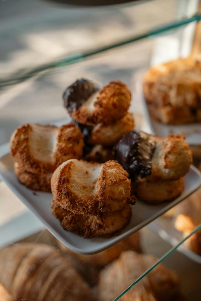Delicious coconut macaroons with chocolate, beautifully displayed in a cozy bakery setting.