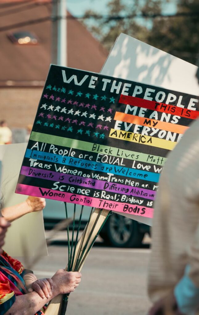 Close-up of a protest sign with slogans supporting equality, acceptance, and diversity during a rally.